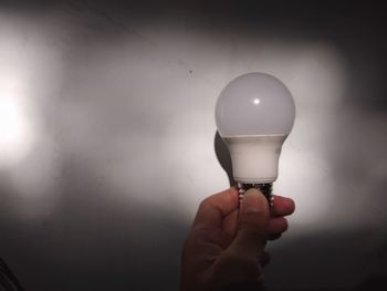 Close-up of hand holding light bulb