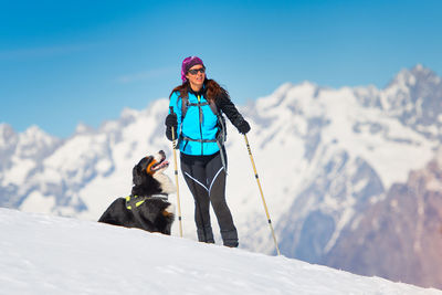 Woman with dog on snow covered mountain
