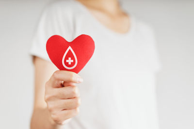 Close-up of woman holding heart shape with hands