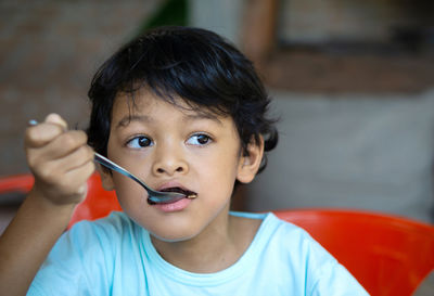 Close-up of boy eating food at home