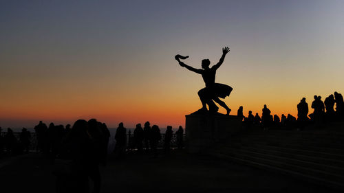 Silhouette people against clear sky during sunset