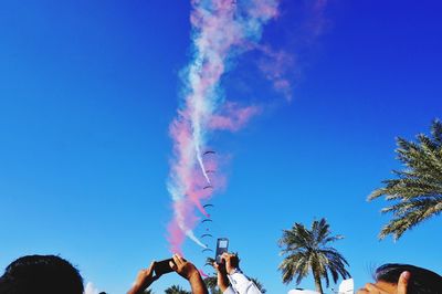 Low angle view of airplane flying against clear blue sky