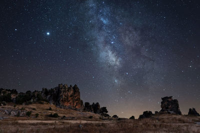 Scenic view of landscape against star field at night