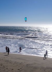 People on beach against clear sky