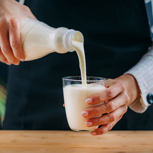 Pouring kefir into glass, a healthy fermented dairy superfood drink