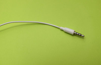 High angle view of telephone on table against green background