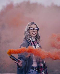 Portrait of young woman standing against sky