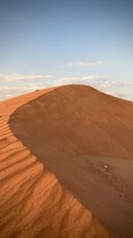 Sand dune in desert against sky