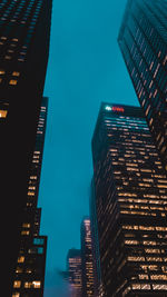 Low angle view of illuminated buildings against sky at night