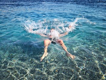 Low section of man swimming in sea