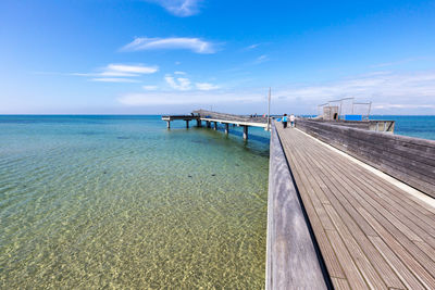 Pier over sea against blue sky