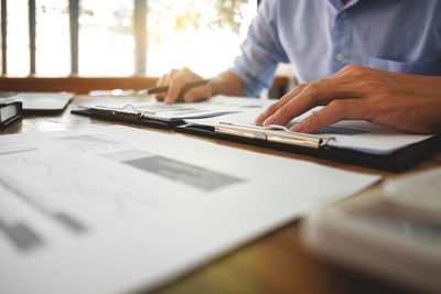 Midsection of man using laptop on table