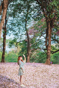 Full length of woman standing by tree