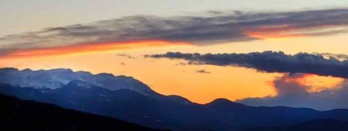 Scenic view of silhouette mountains against sky during sunset