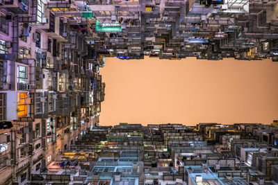 Directly below shot of buildings against clear sky during sunset
