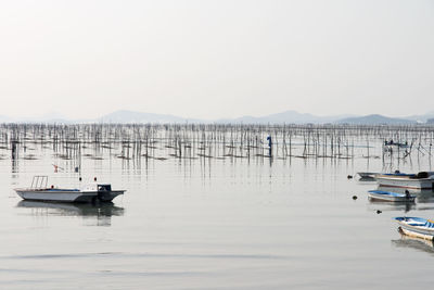 Boats moored in lake against clear sky