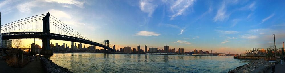 Bridge over river against cloudy sky