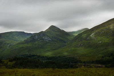 Scenic view of field and mountains against sky