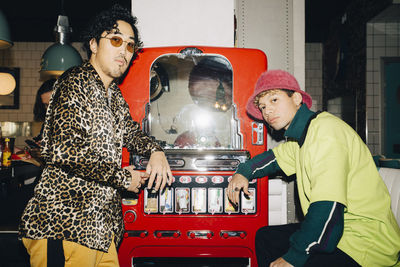 Portrait of man wearing sunglasses with friend in cafe