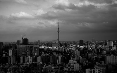 Buildings in city against cloudy sky