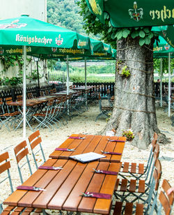 Empty chairs and tables against plants