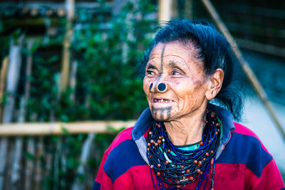 Apatani tribal women facial expression with her traditional nose lobes and blurred background