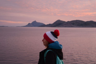 Person looking at sea against sky during sunset