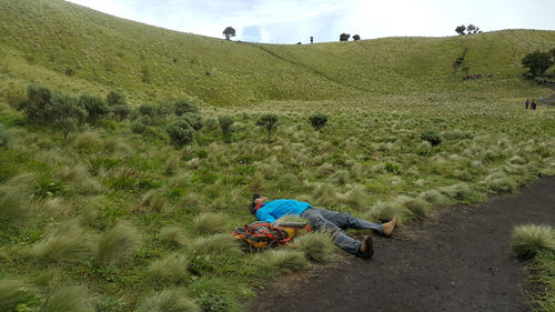 Hiker laying down on field