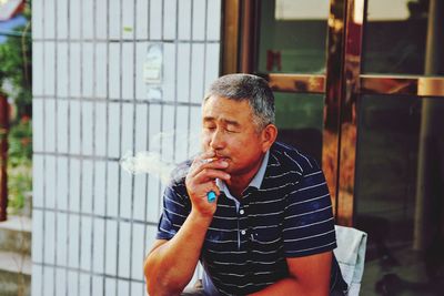 Mid adult man smoking outdoors