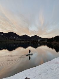 Scenic view of lake by mountains against sky