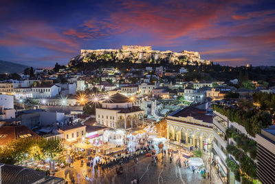 High angle view of illuminated street amidst buildings in city at night