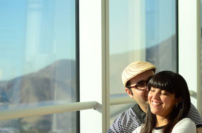 Couple hugging besides window