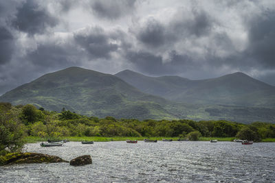 Scenic view of lake by mountains against sky