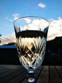 Close-up of beer glass on table against sky