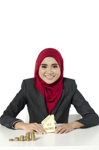 Portrait of a smiling young woman against white background