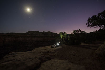 A woman enjoys a full moon near colorado national monument.