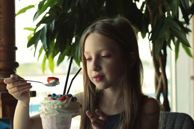 Close-up of girl having ice cream in restaurant