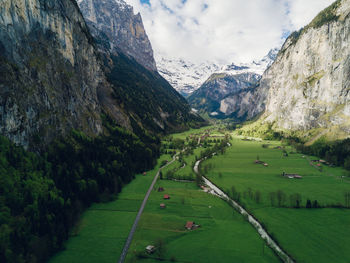 Scenic view of agricultural field by mountains against sky