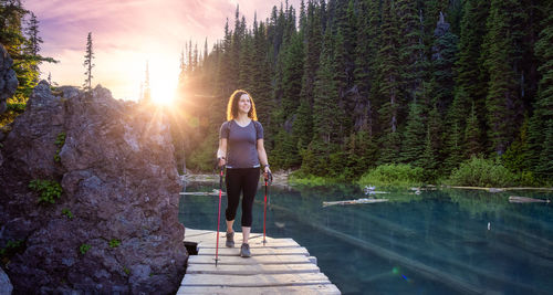 Woman standing by trees against plants