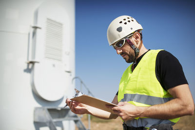 Engineer reading clipboard at construction site