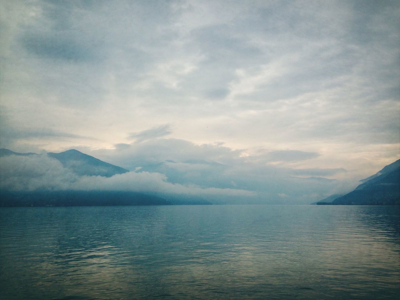 water, tranquil scene, scenics, waterfront, tranquility, sky, beauty in nature, mountain, sea, cloud - sky, nature, cloudy, idyllic, lake, mountain range, cloud, weather, rippled, outdoors, non-urban scene