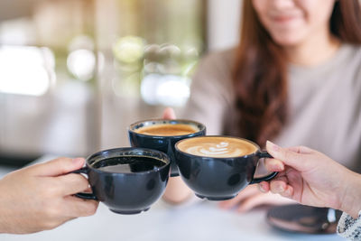 Midsection of woman holding coffee cup