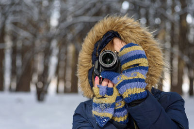 Midsection of woman photographing with snow