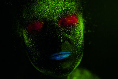 Woman with eyes closed in neon make-up