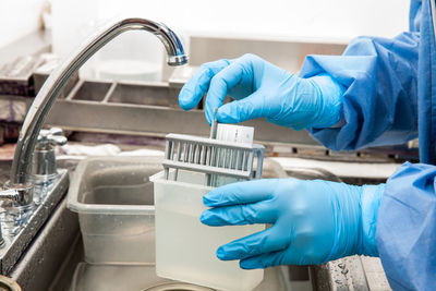 Cropped hand of scientist examining chemical in laboratory