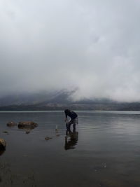 Men in sea against sky