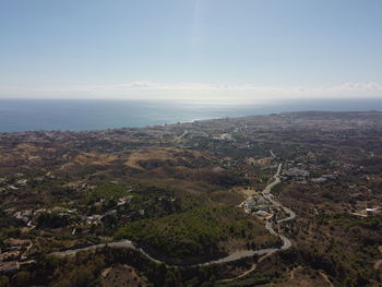 Aerial view of city by sea against sky