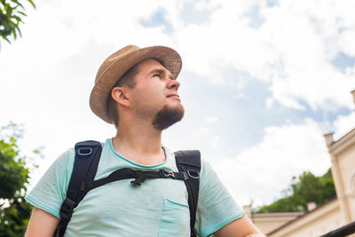 Portrait of young man looking away against sky