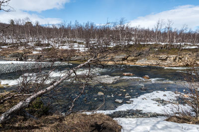 Scenic view of river against sky during winter