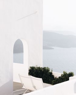 White building by sea against sky